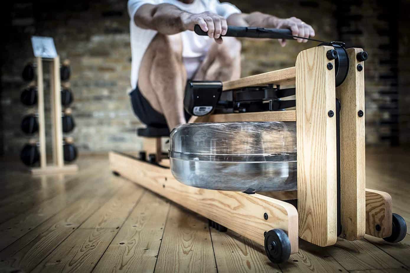 A man is rowing on the WaterRower Natural Rowing Machine with S4 Monitor