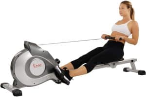 A lady is rowing with the Sunny Health and Fitness SF-RW5515 Magnetic Rowing machine