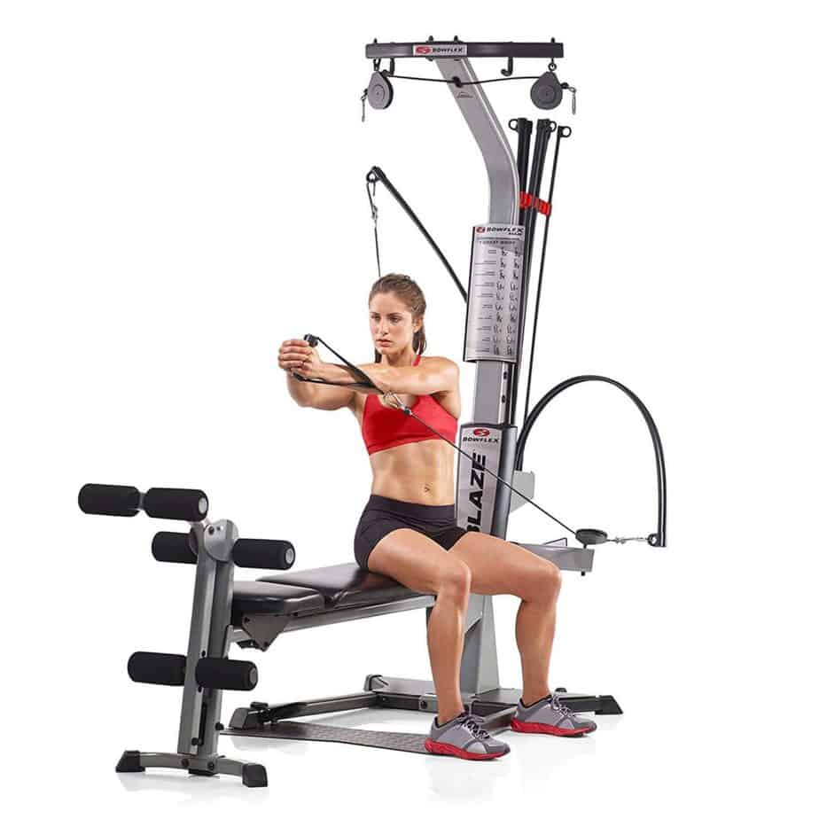 A woman is exercising on the Bowflex Blaze Home Gym
