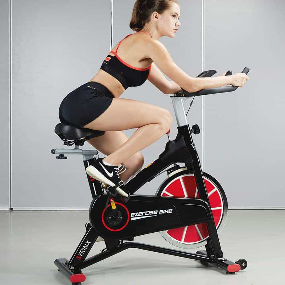 A lady is riding on the Syrinx Indoor Cycling Bike