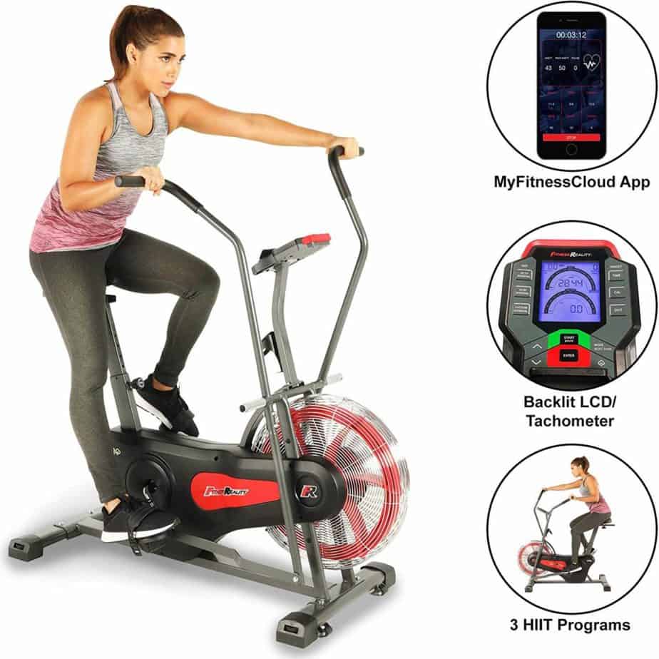 A lady is riding the Fitness Reality 1000AR Bluetooth Air Resistance Bike