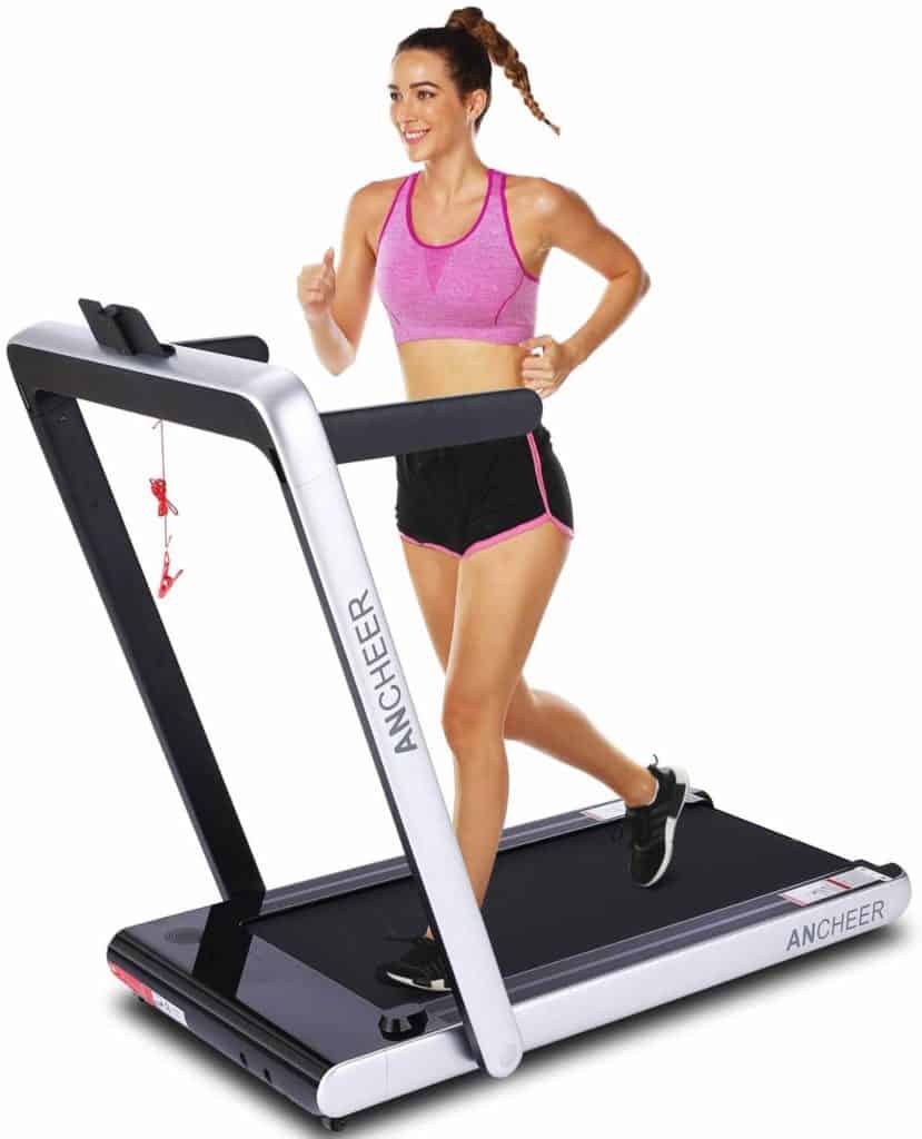 A lady using the ANCHEER 2-in-1 Folding Treadmill with the stands and handlebars up
