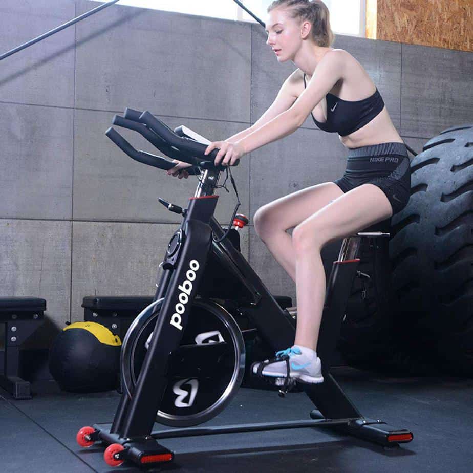 A lady athlete riding the Pooboo D578 Indoor Cycling Bike