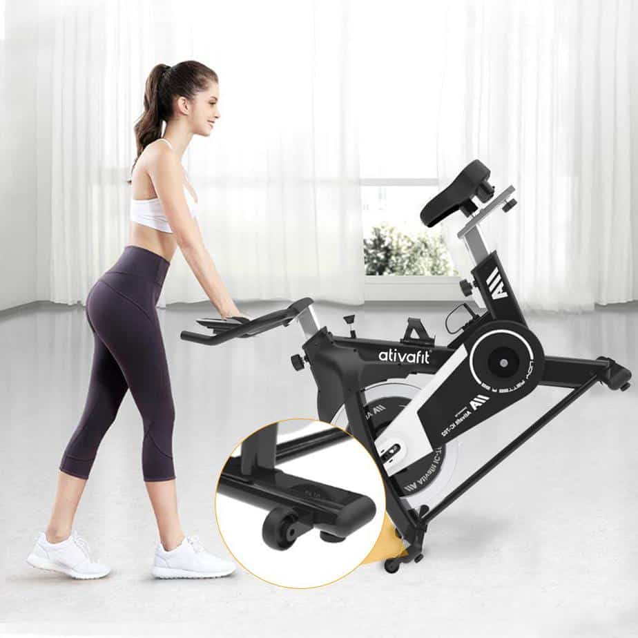 A lady is moving the Ativafit IC-702 Indoor Cycling Bike to storage