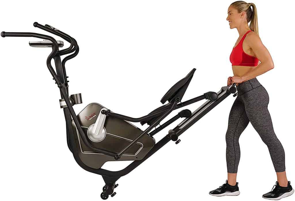 A lady is moving the Sunny Health and Fitness SF-3862 Elliptical to storage