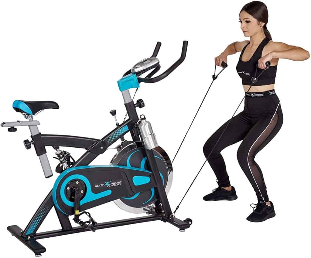 A lady is performing the upright rows with the resistance bands on the Body Xtreme Fitness Bundle BXF004 Exercise Bike