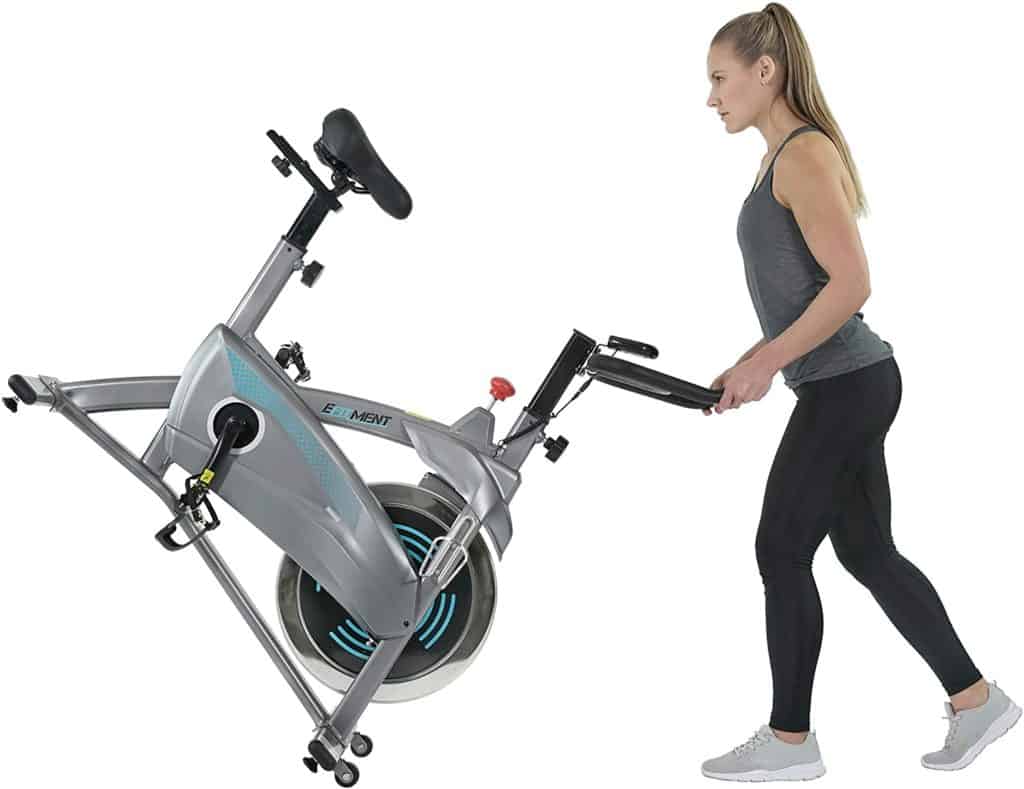 A lady moves the EFITMENT IC037 Indoor Cycling Bike to storage