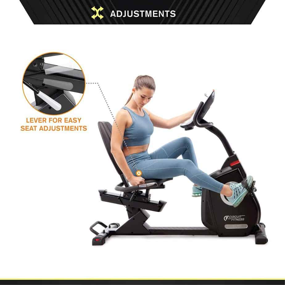 A lady working on the Circuit Fitness AMZ-587R Magnetic Recumbent Bike and also adjusting the seat