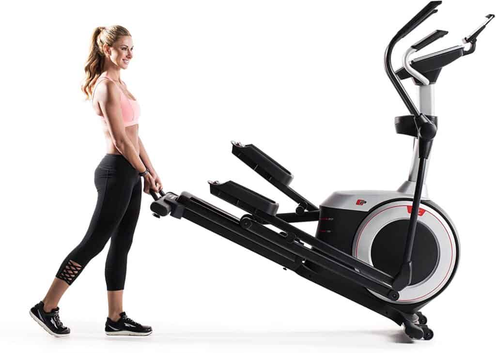 A lady rolls the ProForm Endurance 520 E Elliptical Trainer for storage