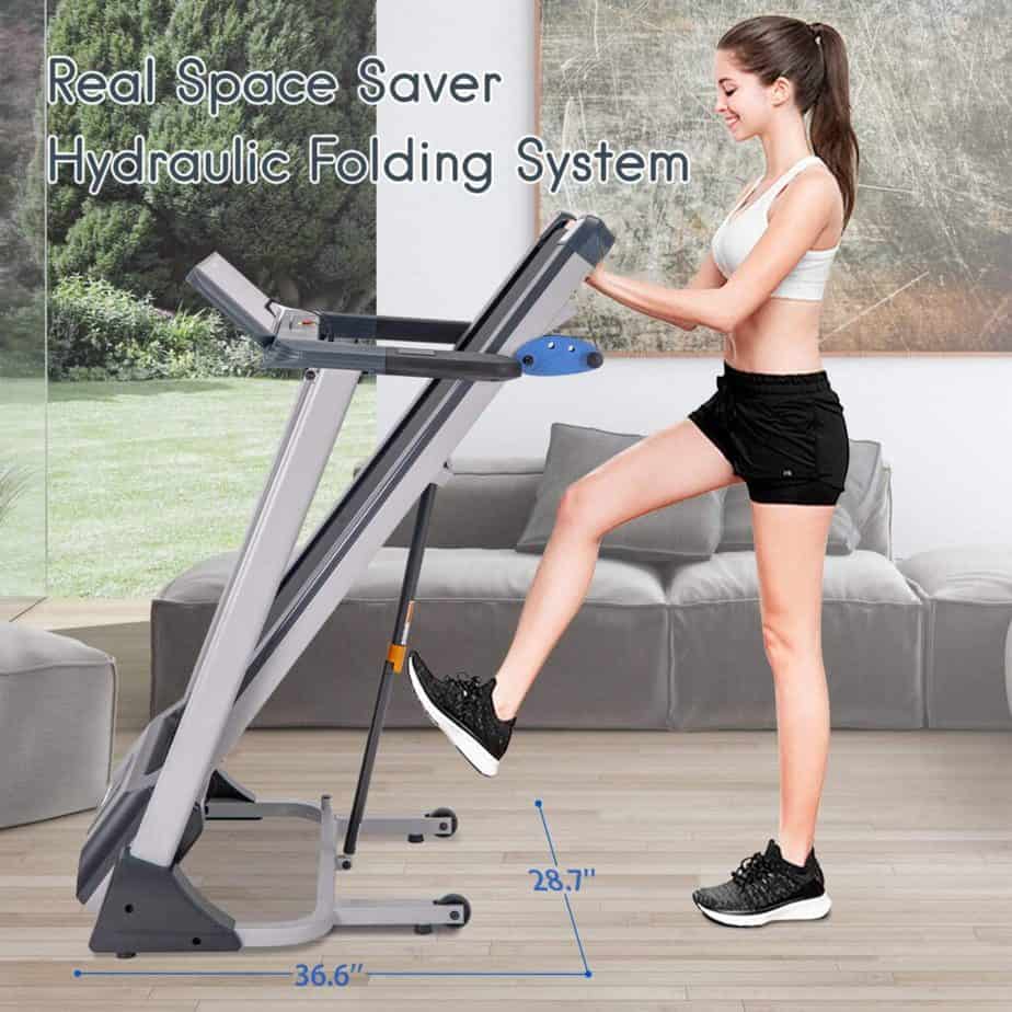 A user tries to unfold the Merax Folding Electric Treadmill