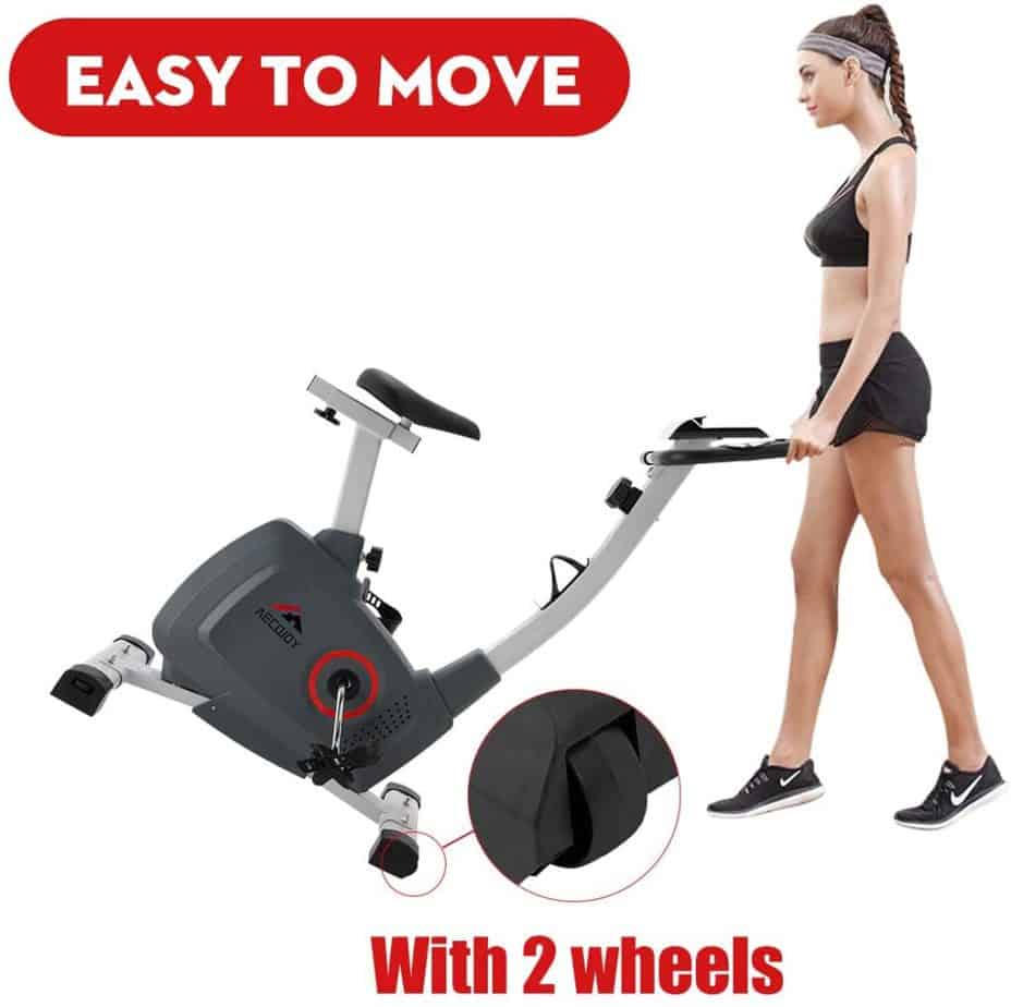 A lady moves the AECOJOY Upright Magnetic Exercise Bike to storage area