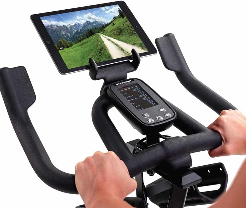 The console, and the handlebar of the Schwinn IC4 Indoor Cycling Exercise Bike with a tablet device on the holder