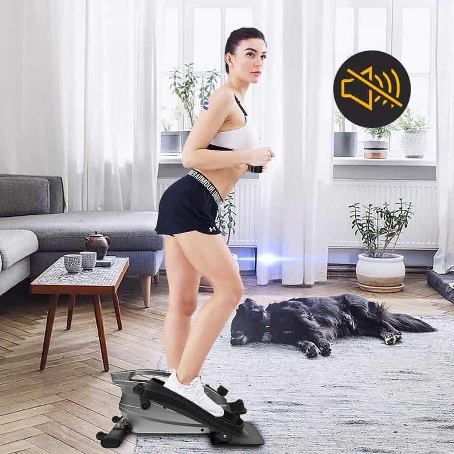 A lady exercises while standing on the Ativafit Under-Desk Elliptical Bike