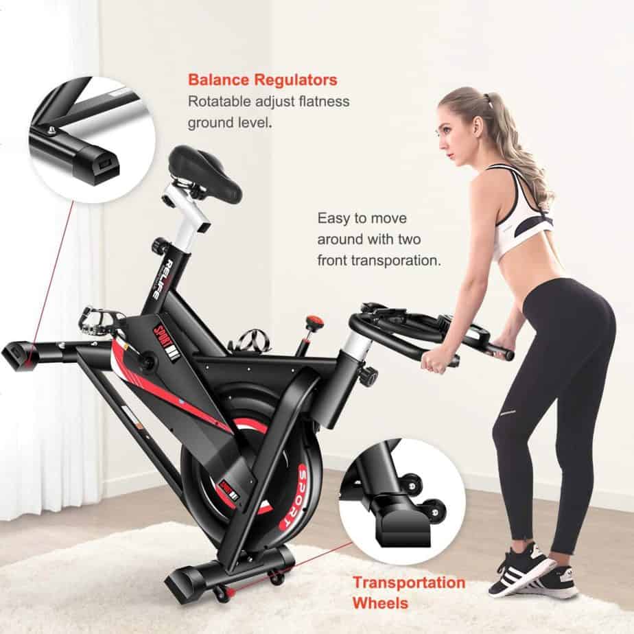 A lady moves the RELIFE REBUILD YOUR LIFE Indoor Cycling Bike for storage