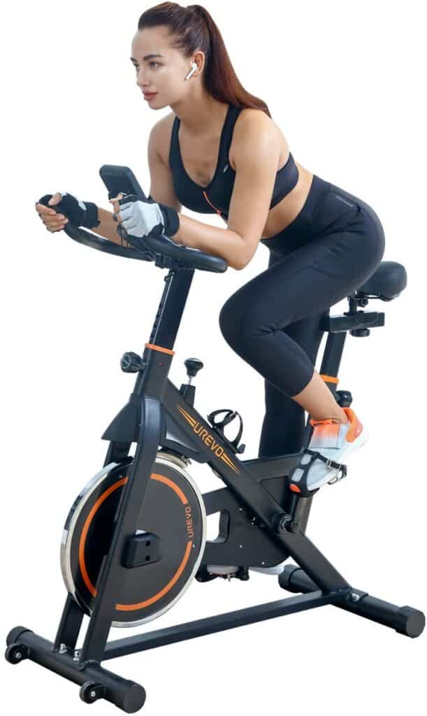 A lady exercises with the UREVO Belt Drive Indoor Cycling Bike in a racing position 