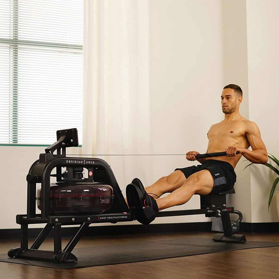 A gentleman works out with the Sunny Health & Fitness SF-RW5713 Obsidian Surge 500 Rowing Machine 