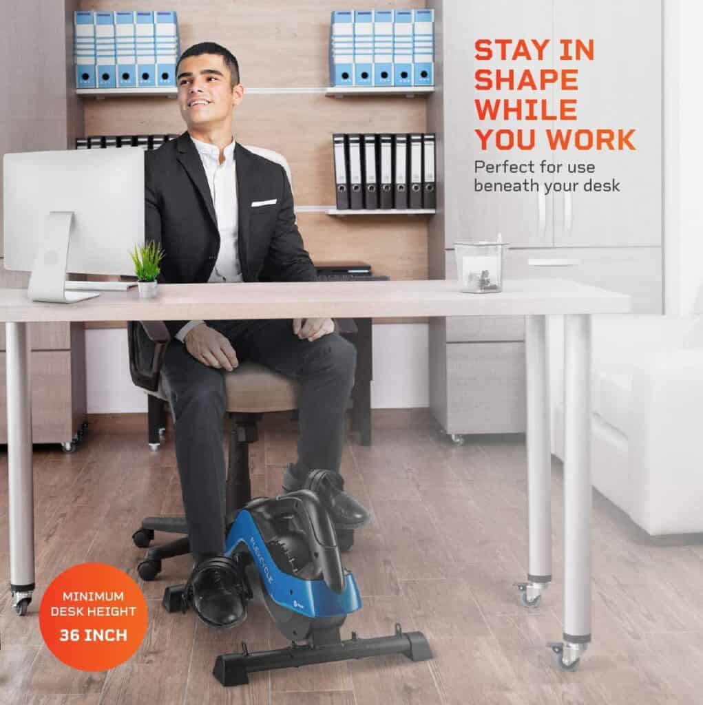 A man uses the LifePro FlexCycle Exercise Bike under a desk while working