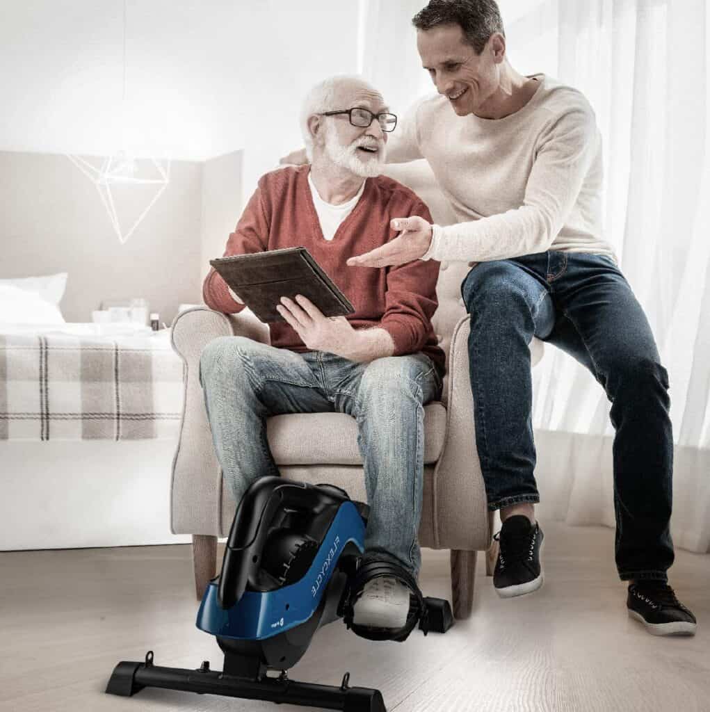 An elderly man workouts with the LifePro FlexCycle Exercise Bike while seated on a sofa