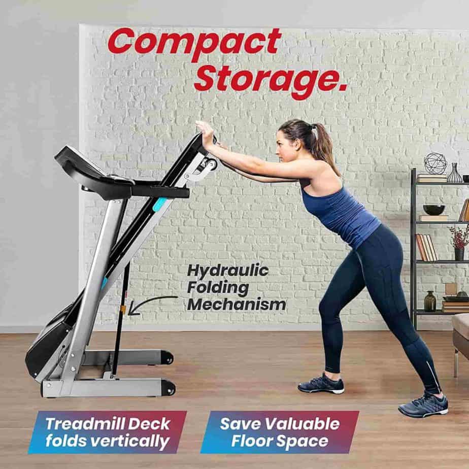 A lady pushes the SereneLife SLFTRD35 Foldable Treadmill to storage