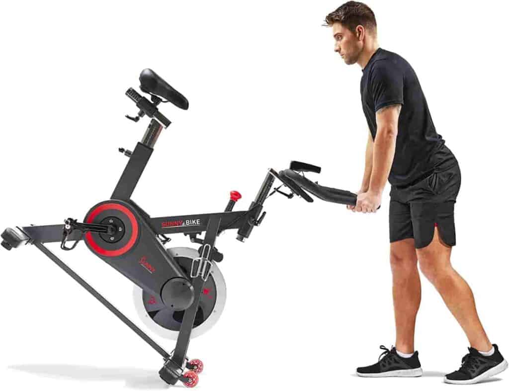 Man rolls away the Sunny Health & Fitness SF-B1805SMART Exercise Bike for storage