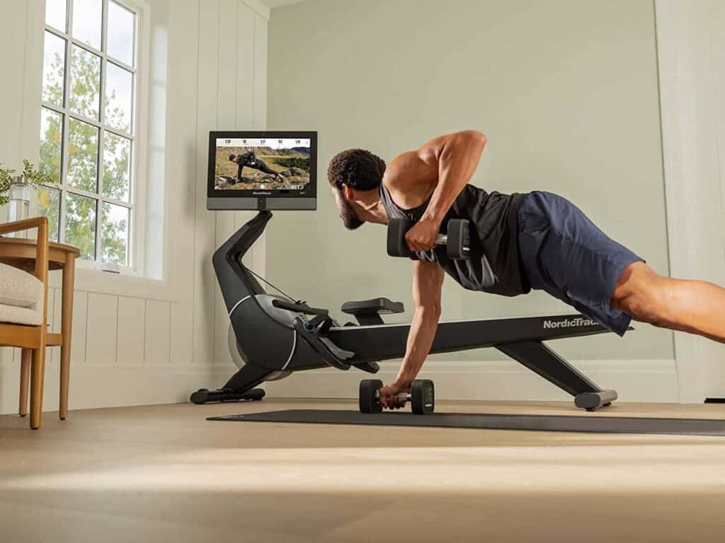 Man does strength training while viewing the workouts on the 22'' HD touchscreen