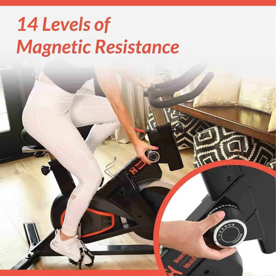 The user adjusts the resistance level of the Women’s Health Men’s Health Eclipse Indoor Cycling Bike via the dial knob