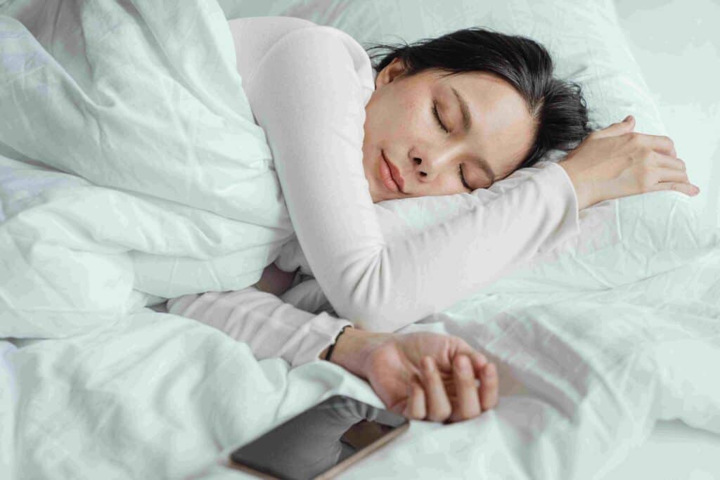 A woman sleeps peacefully on a bed