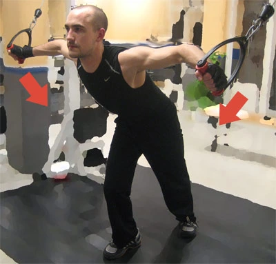 Man does cable shoulder exercise