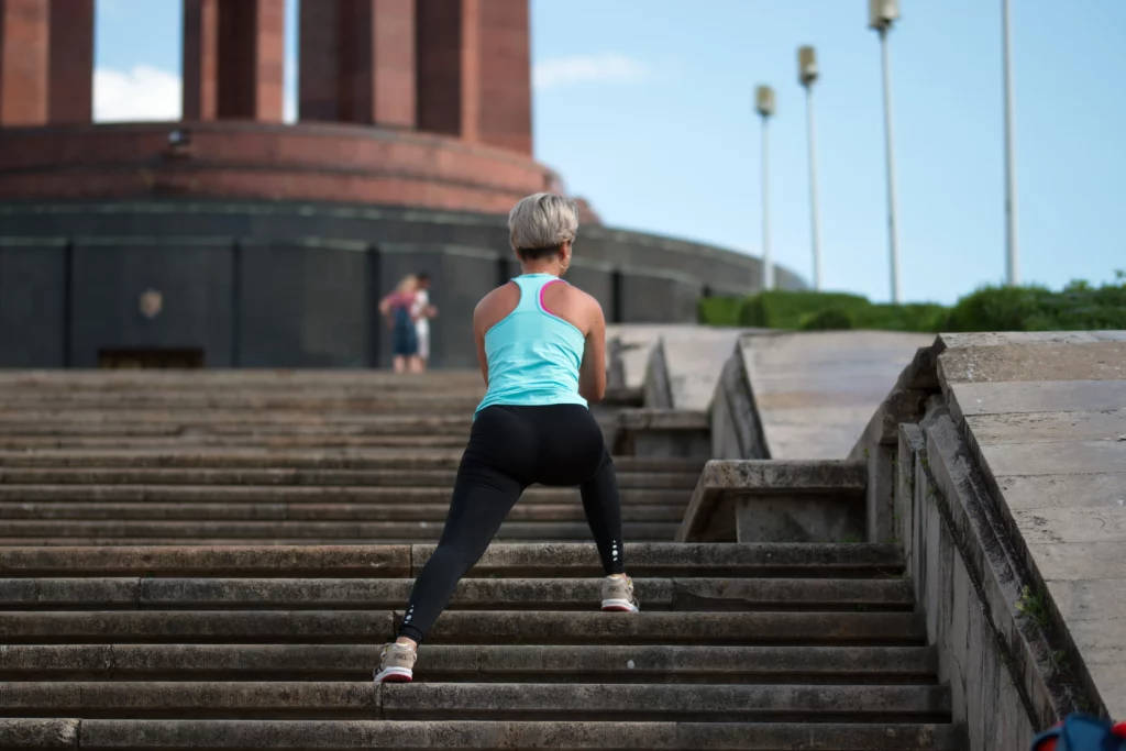 A woman exercises by running up the steps