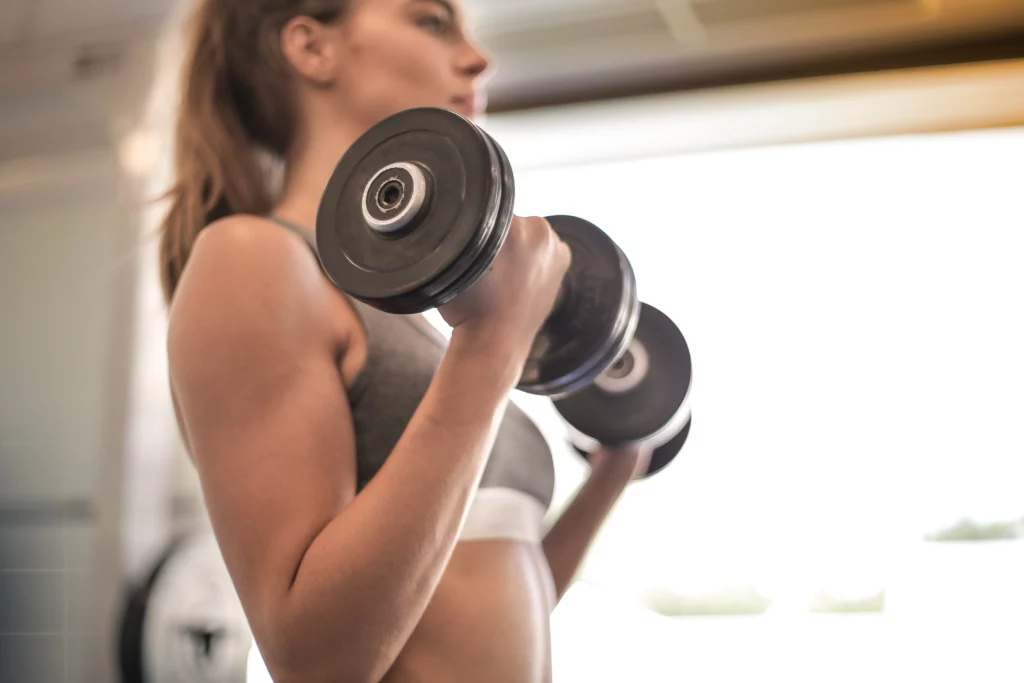 Woman does bicep curls with a set of dumbbells