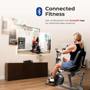 Lady exercises with the Sunny Health & Fitness Recumbent Bike SF-RB423034 while wathing TV